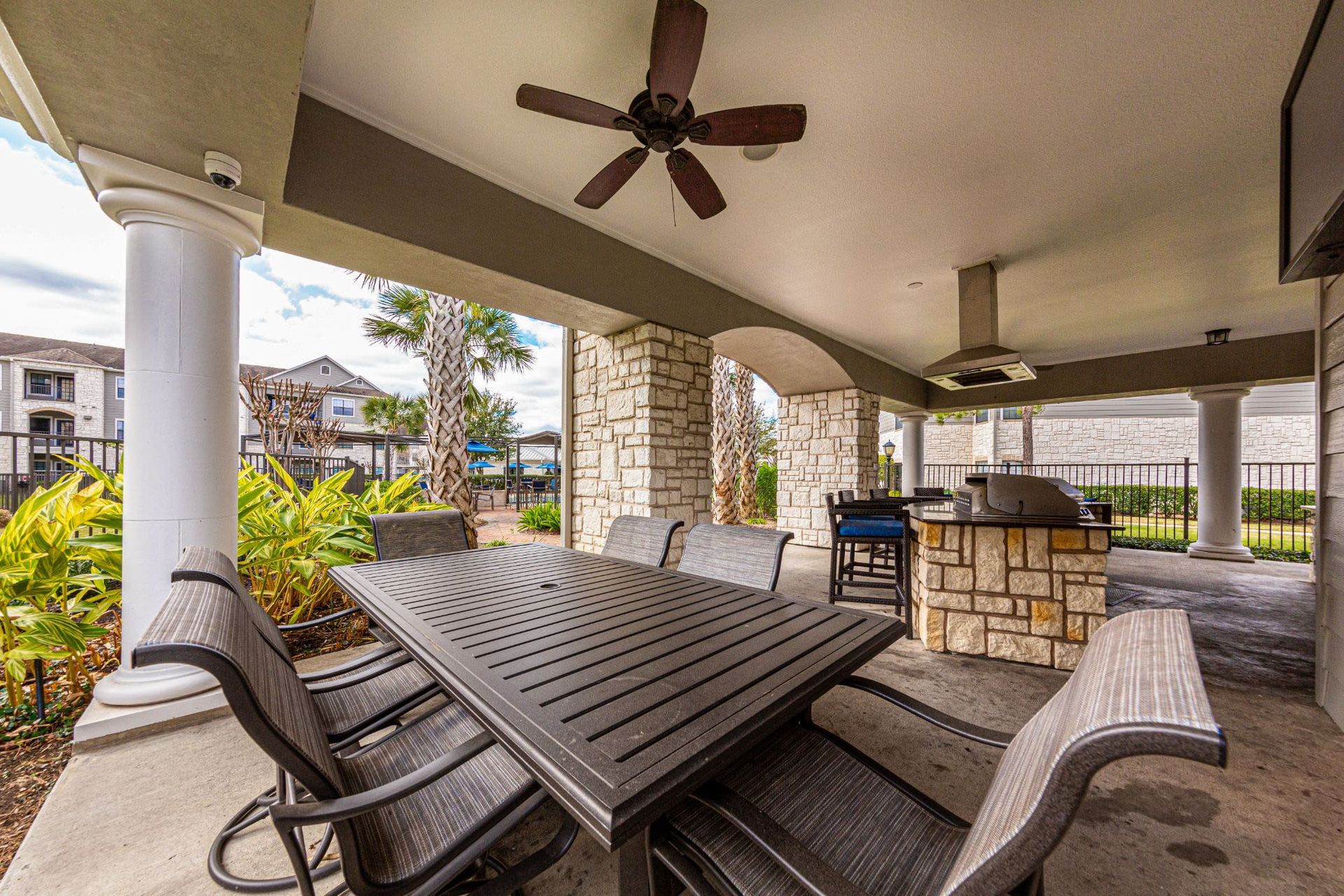 A patio with a table and chairs and a ceiling fan at Marquis Grand Lakes in Richmond, TX.