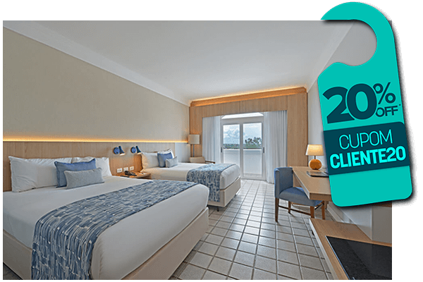 Quarto de hotel com duas camas, detalhes em azul e um aviso de porta com 20% de desconto.
