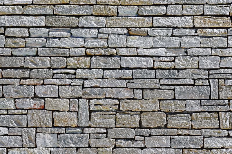 Gray stone brick wall with varying sizes and textures.