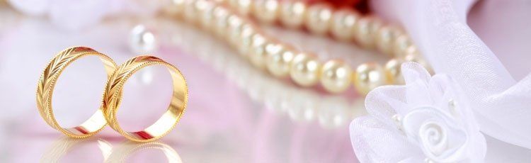 anelli e collana di perle su un tavolo rosa