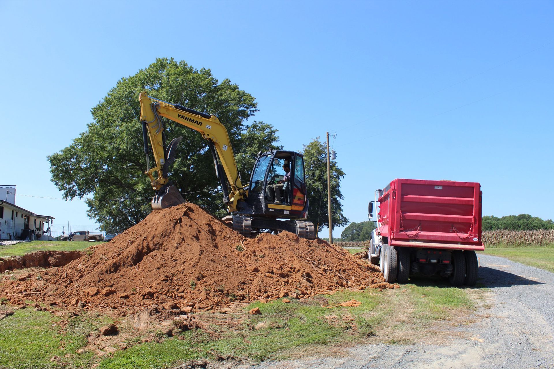 An excavator is loading dirt into a dump truck.