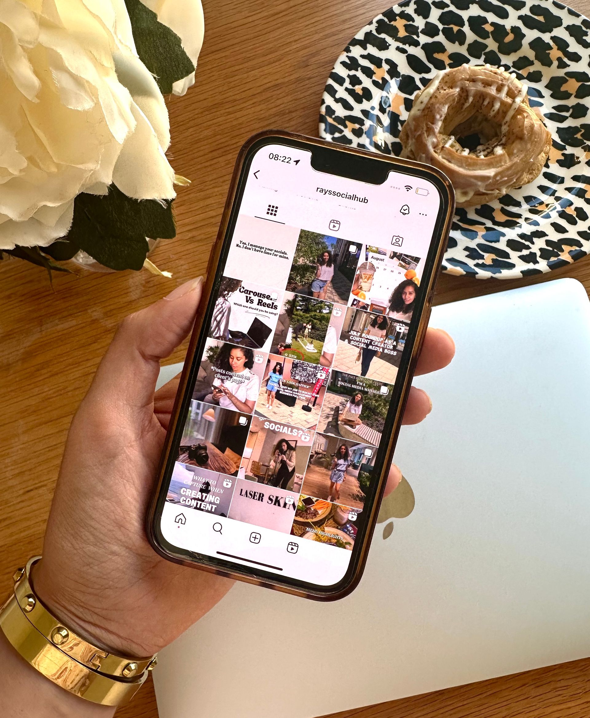 Person using a smartphone, tapping the screen. Coffee cup, notebook, and pen on a white table.