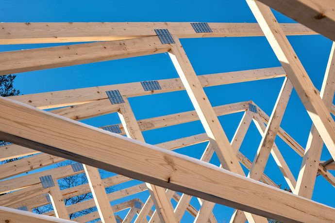 A row of wooden beams are against a blue sky.