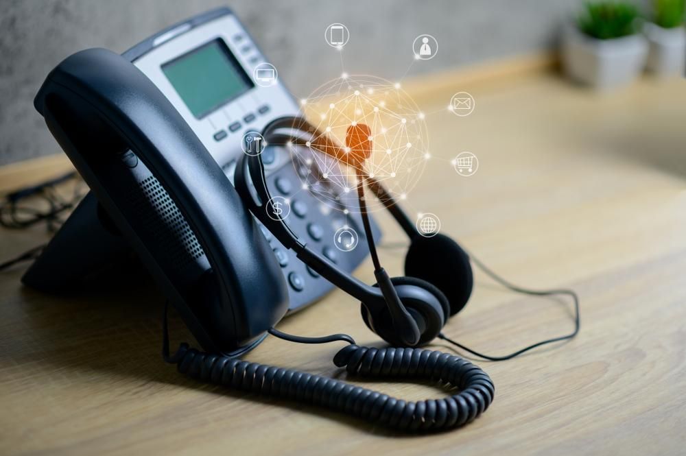 A Telephone With a Headset Attached to It is Sitting on a Wooden Table — River City Communications In Melinga, NSW