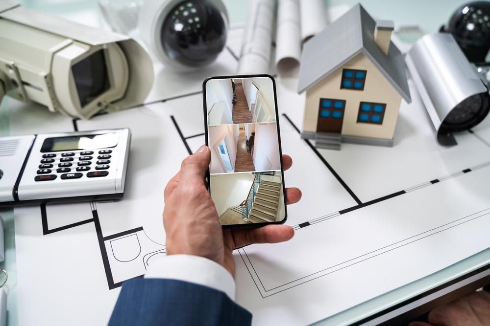A Person is Holding a Cell Phone With a Picture of a House on It — River City Communications In Wingham, NSW