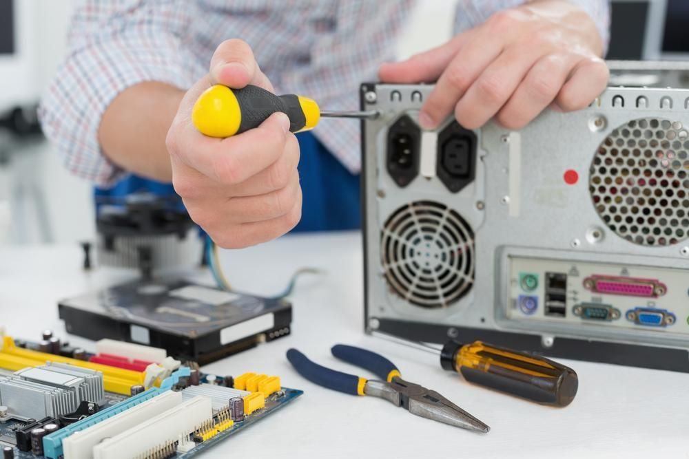 A Man is Fixing a Computer With a Screwdriver — River City Communications In Melinga, NSW