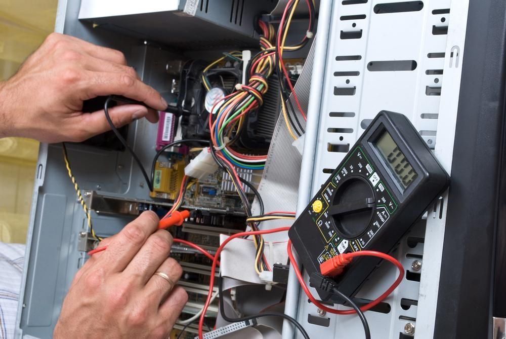 A Man is Working on a Computer With a Multimeter — River City Communications In Gloucester, NSW