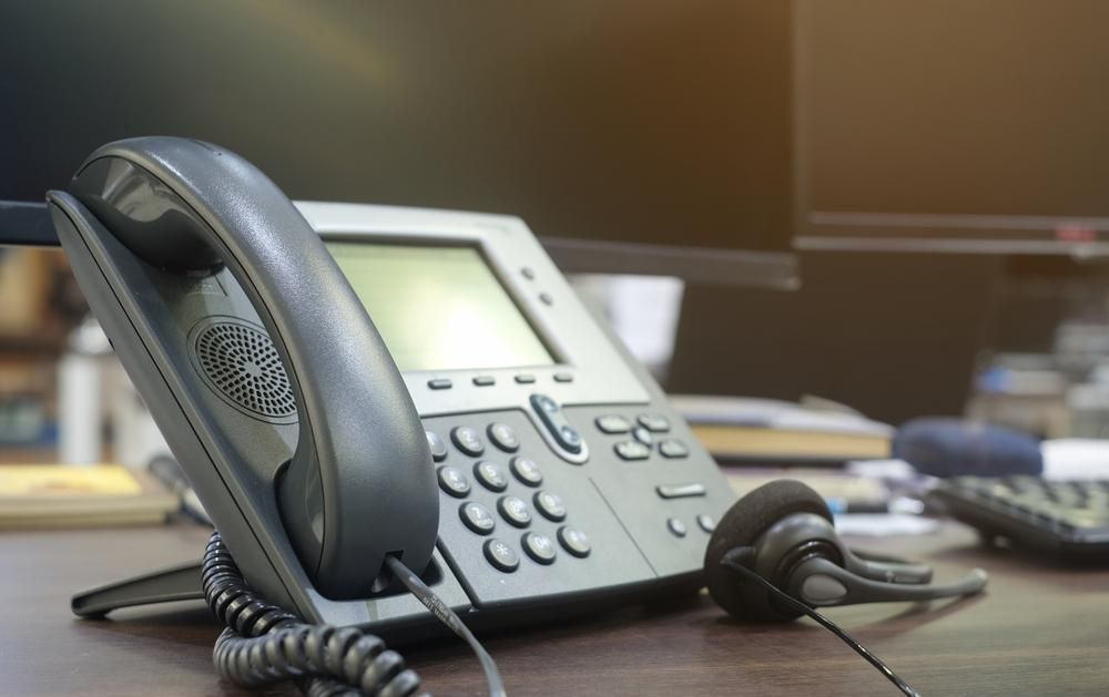 A Telephone is Sitting on a Desk Next to a Computer Monitor — River City Communications In Melinga, NSW