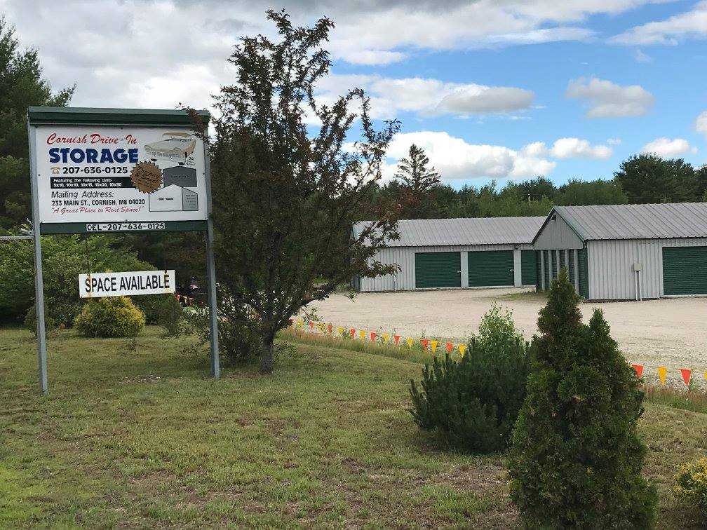 A sign for a storage facility is in front of a building.