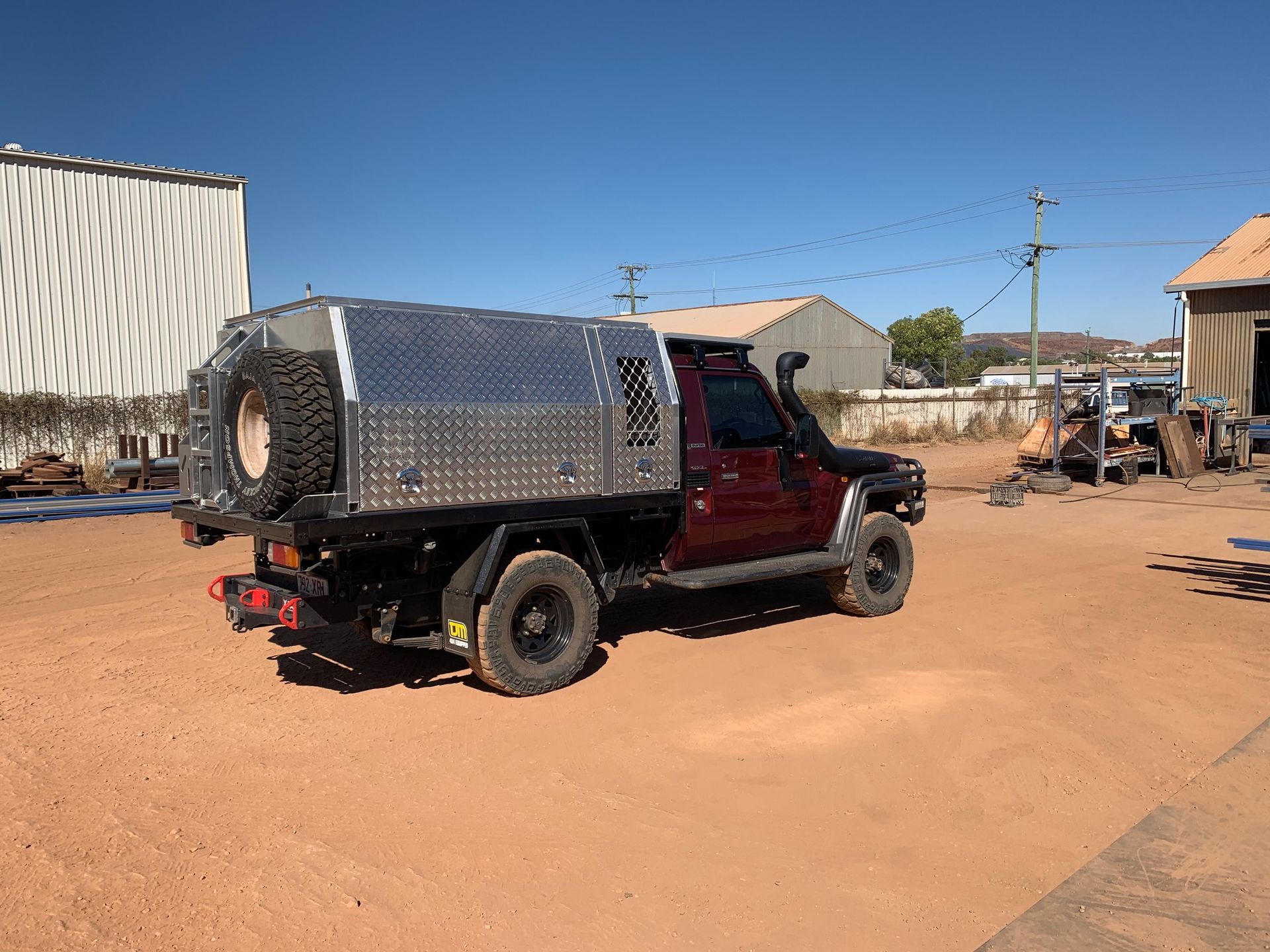A Brown Truck With a Tray Bed is Parked in a Dirt Lot — Wright's Welding Operations In Ryan, QLD