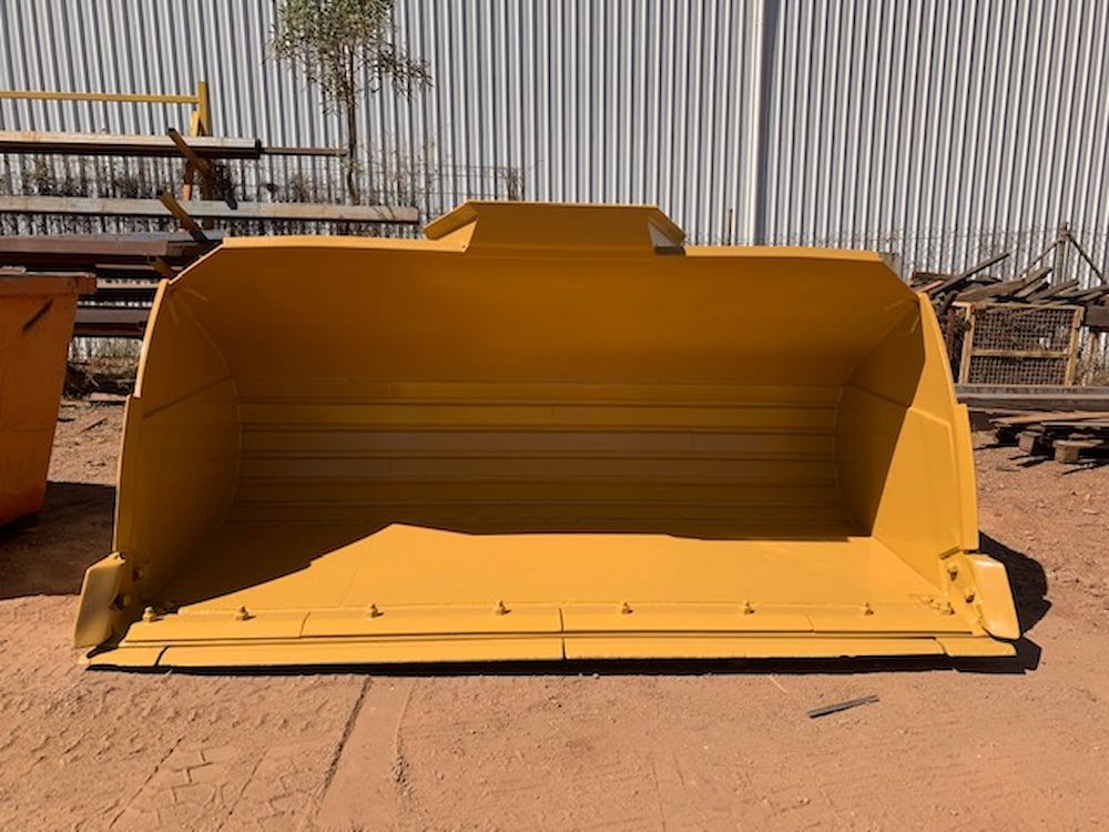 A Yellow Bucket is Sitting on the Ground in Front of a Building — Wright's Welding Operations In Ryan,  QLD