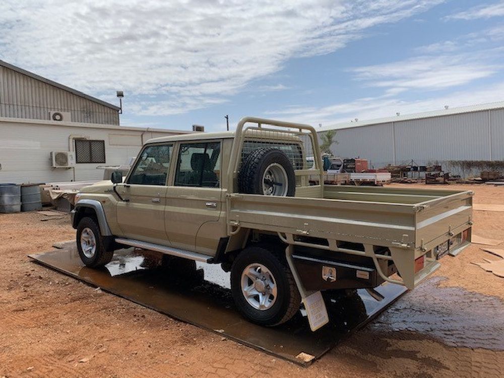 A Brown Truck With a Tray Bed is Parked in a Dirt Lot — Wright's Welding Operations In Ryan, QLD