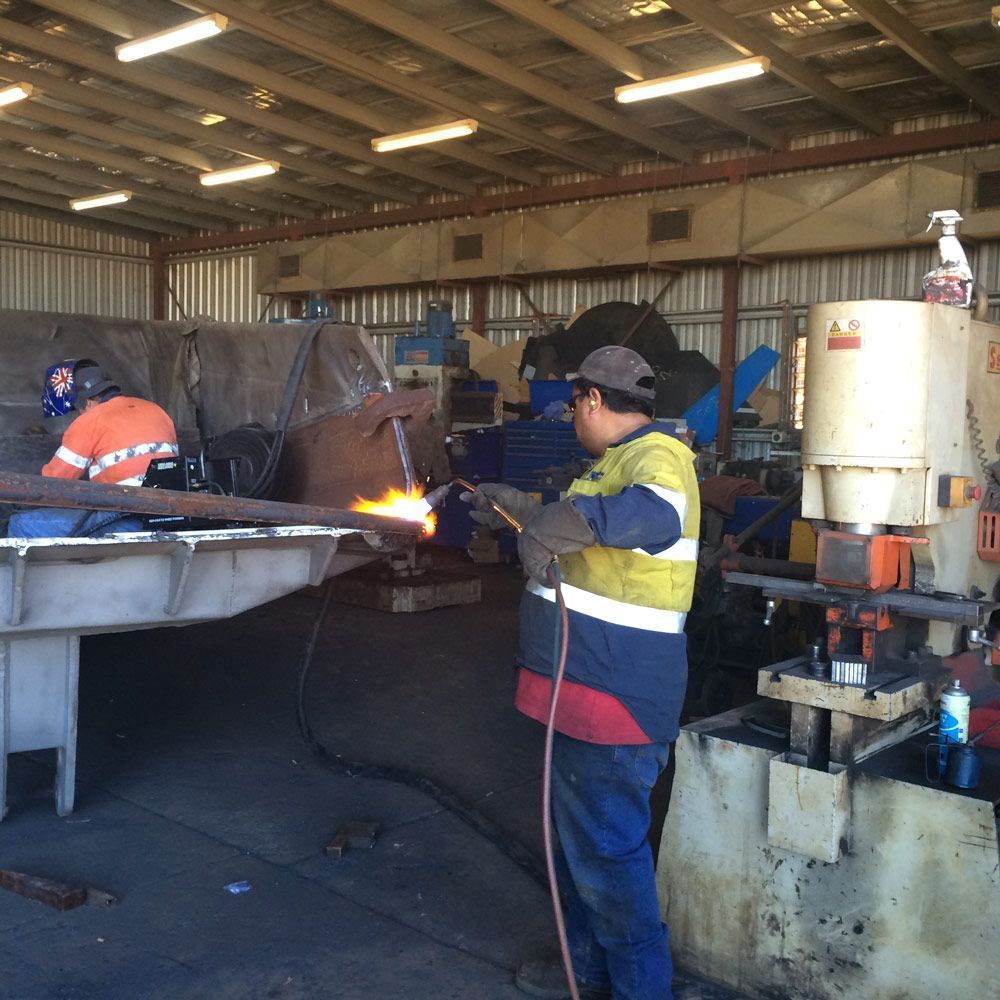 Men Welding Workers Repairing The Heavy Equipment On The Shop — Wright's Welding Operations In Ryan, QLD
