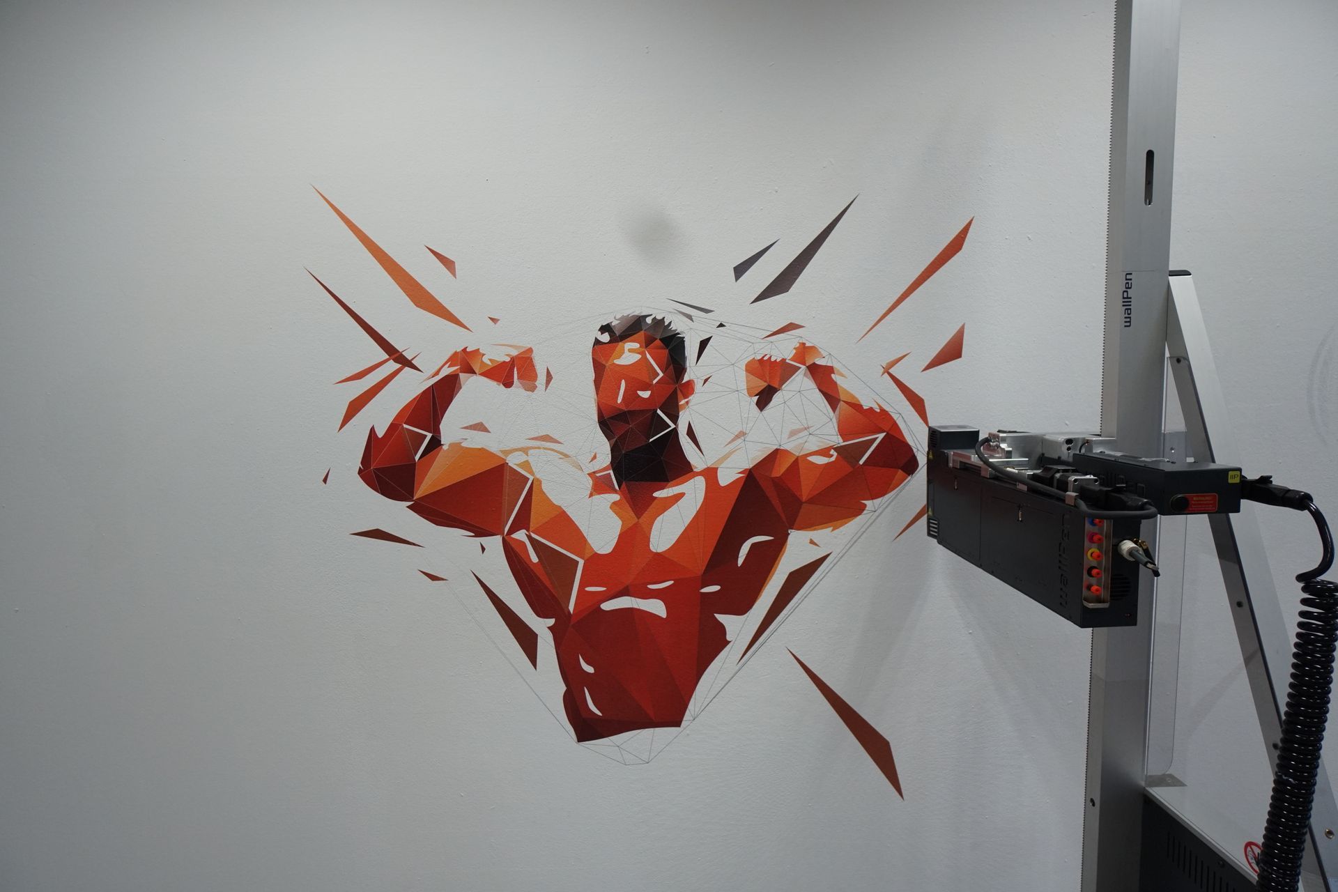 Een muur met een geometrisch ontwerp van een bodybuilder en een machine die het ontwerp print.