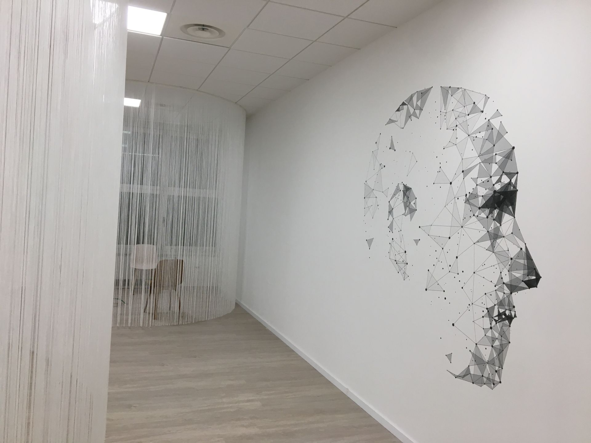 Witte gang met geometrisch gezicht op de muur, abstract gordijn bij de gebogen opening.