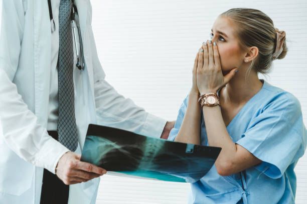 A doctor is holding an x-ray of a patient 's shoulder.