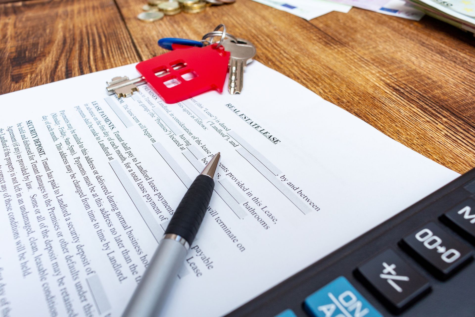 Una penna è posizionata sopra un pezzo di carta accanto a una calcolatrice.