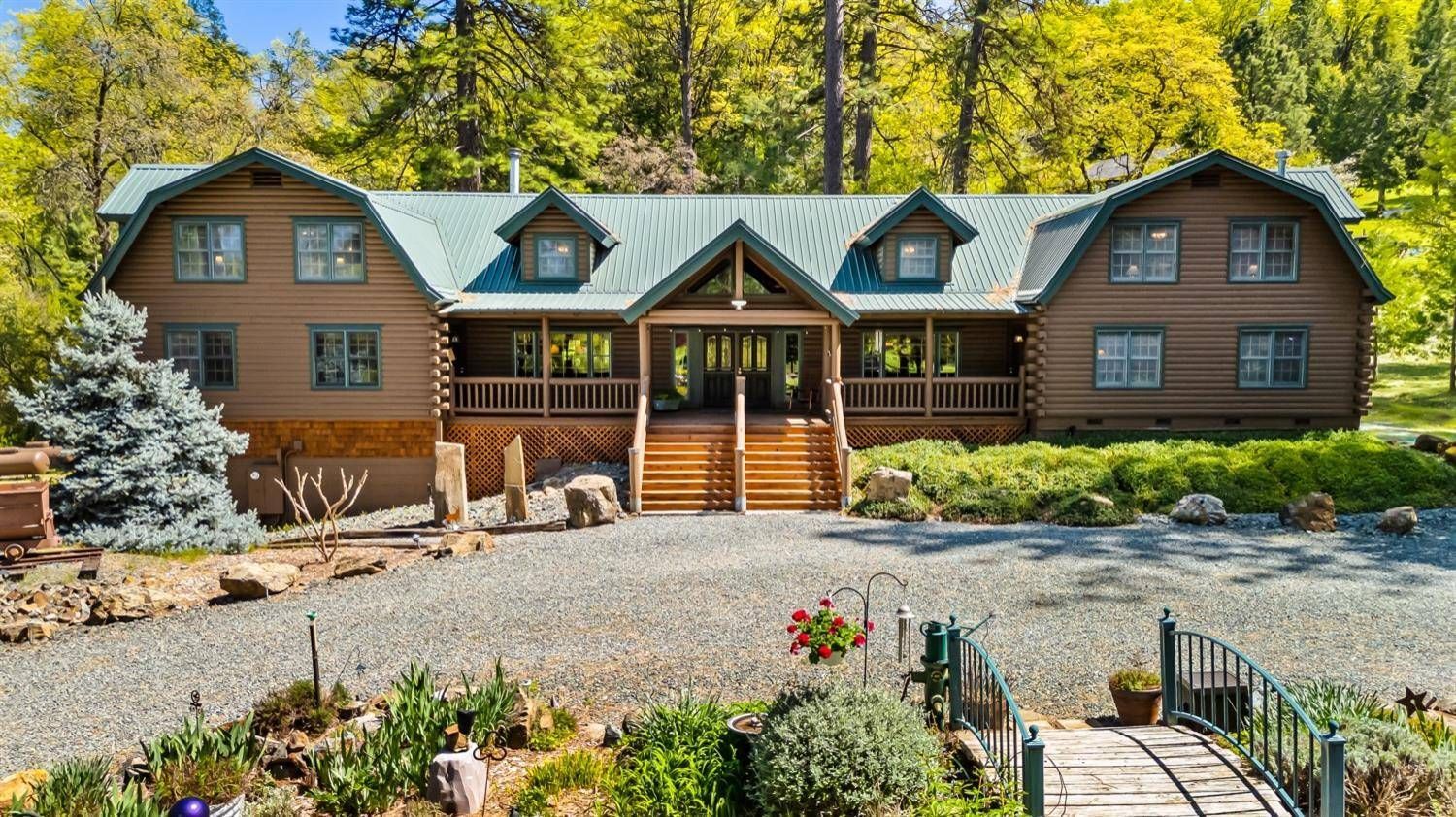 An aerial view of a large log cabin surrounded by trees. Gayle Morris  Real Estate | GUIDE Real Estate - Auburn, CA Real Estate