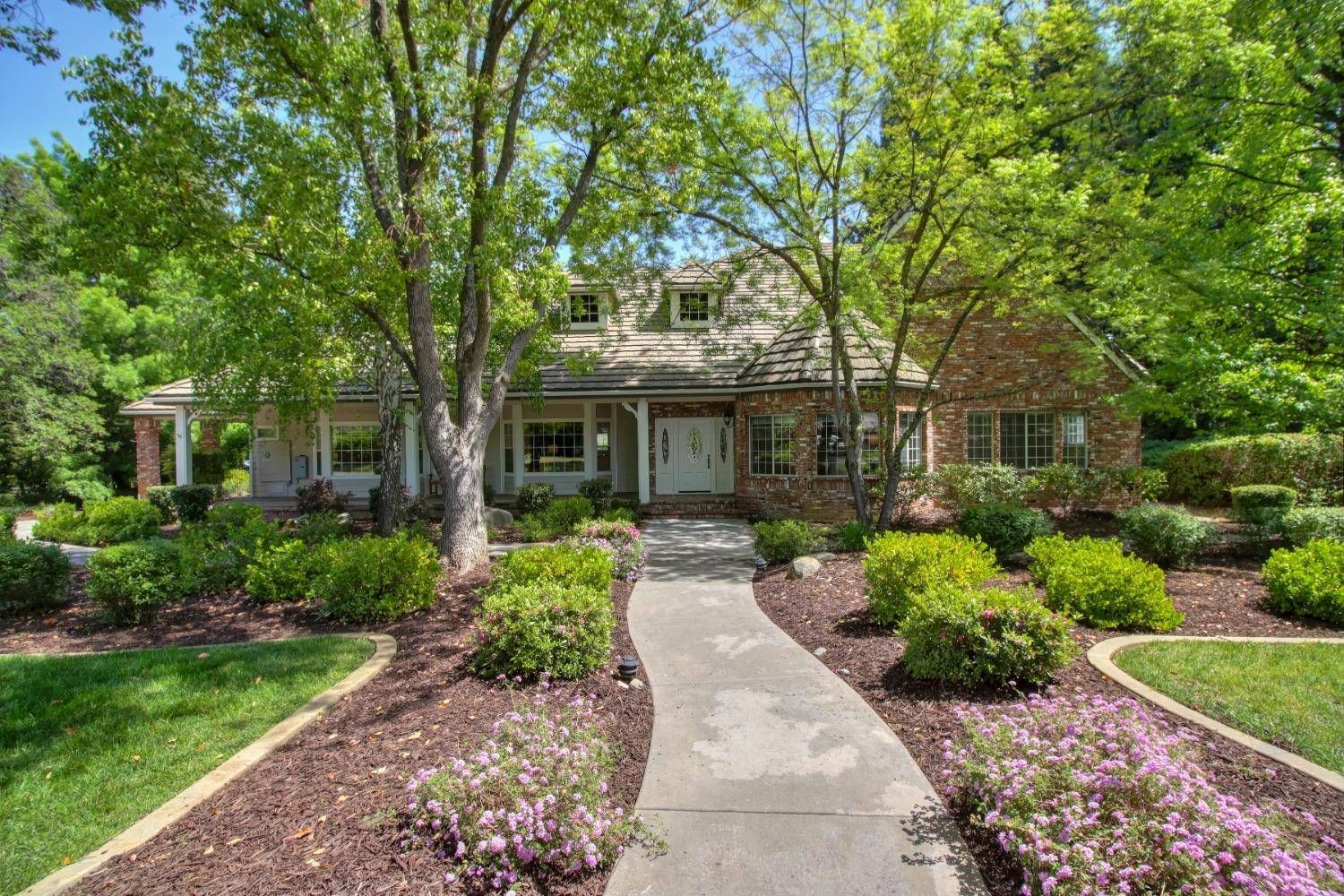 A large brick house with a walkway leading to it surrounded by trees and. bushes. Gateway Commons - Gayle Morris  Real Estate | GUIDE Real Estate - Auburn, CA Real Estate