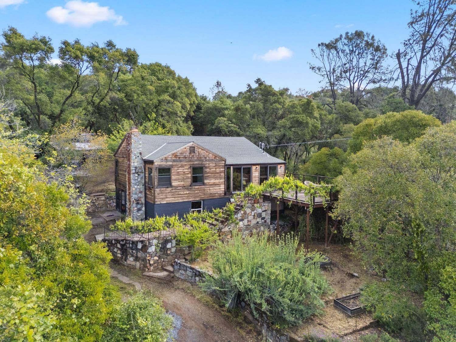 An aerial view of a house in the middle of a forest surrounded by trees. Gayle Morris  Real Estate | GUIDE Real Estate - Auburn, CA Real Estate