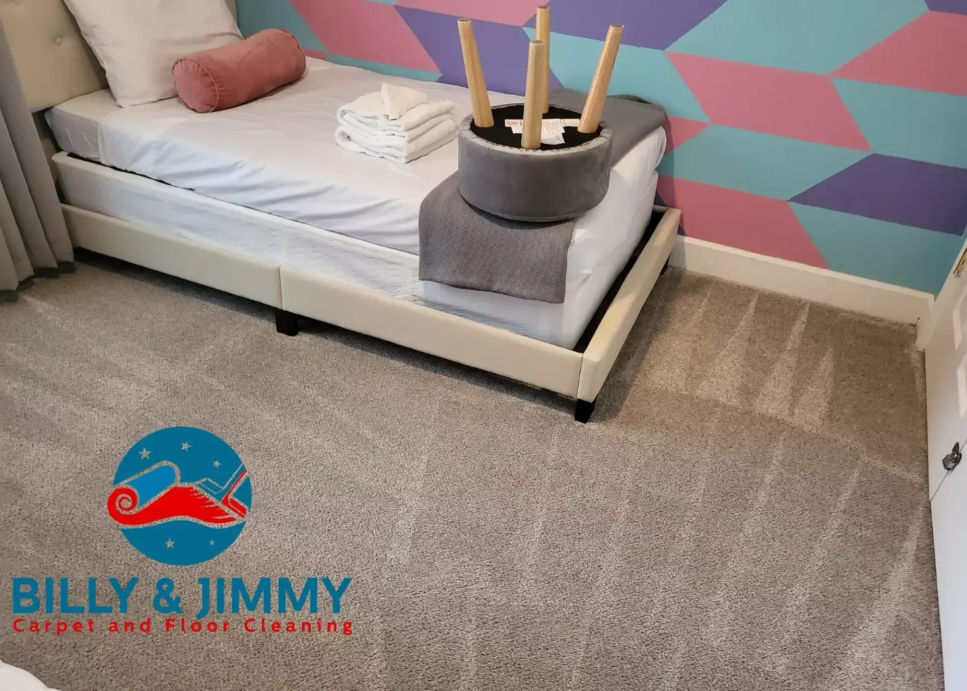 a bedroom with a bed and a stool in it .