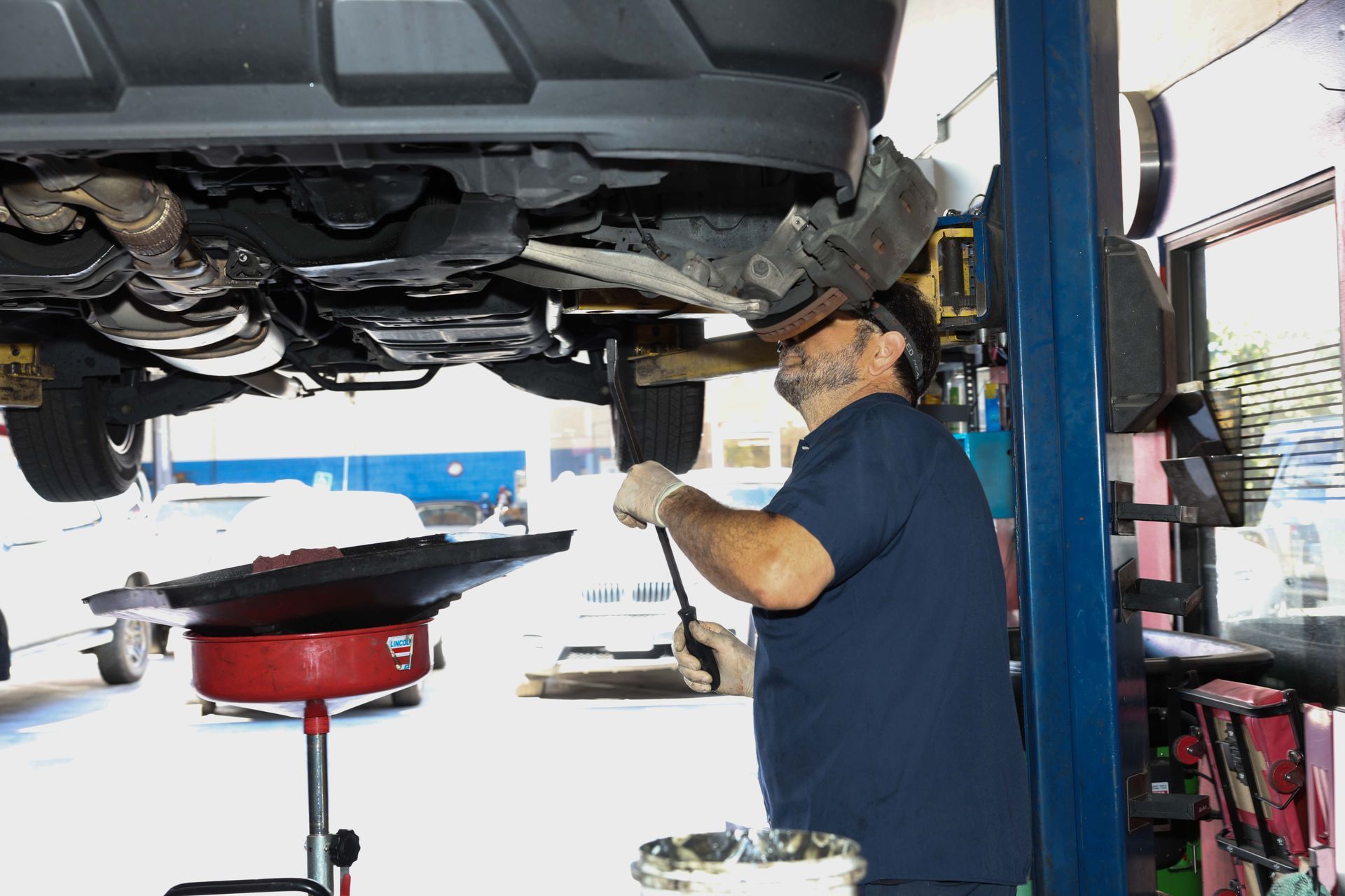 Mechanic under a car | Omega Automotive