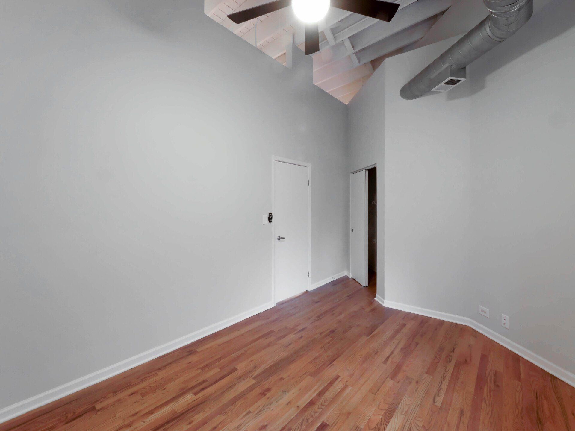 An empty room with hardwood floors and a ceiling fan at 1550 North Damen.