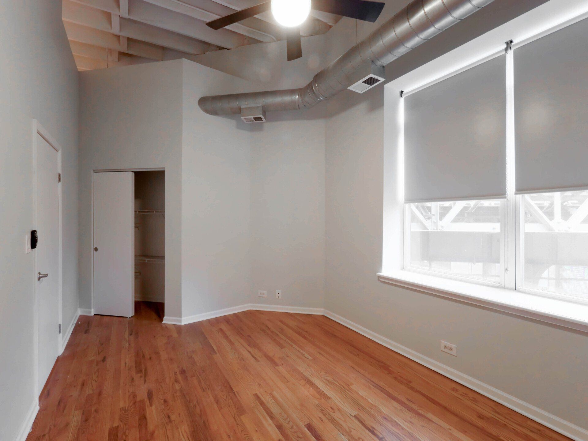 An empty room with hardwood floors and a ceiling fan at 1550 North Damen.