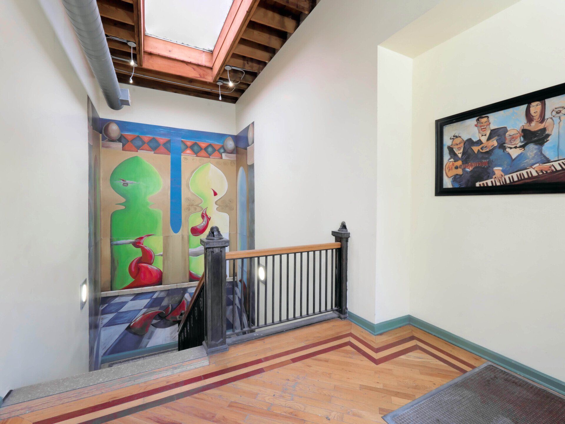 A staircase with a painting on the wall and a picture on the wall at 1550 North Damen.