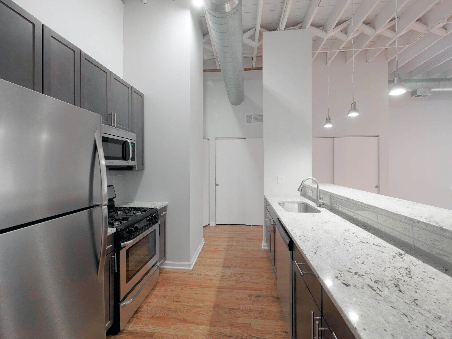 A kitchen with stainless steel appliances and granite counter tops at 1550 North Damen.