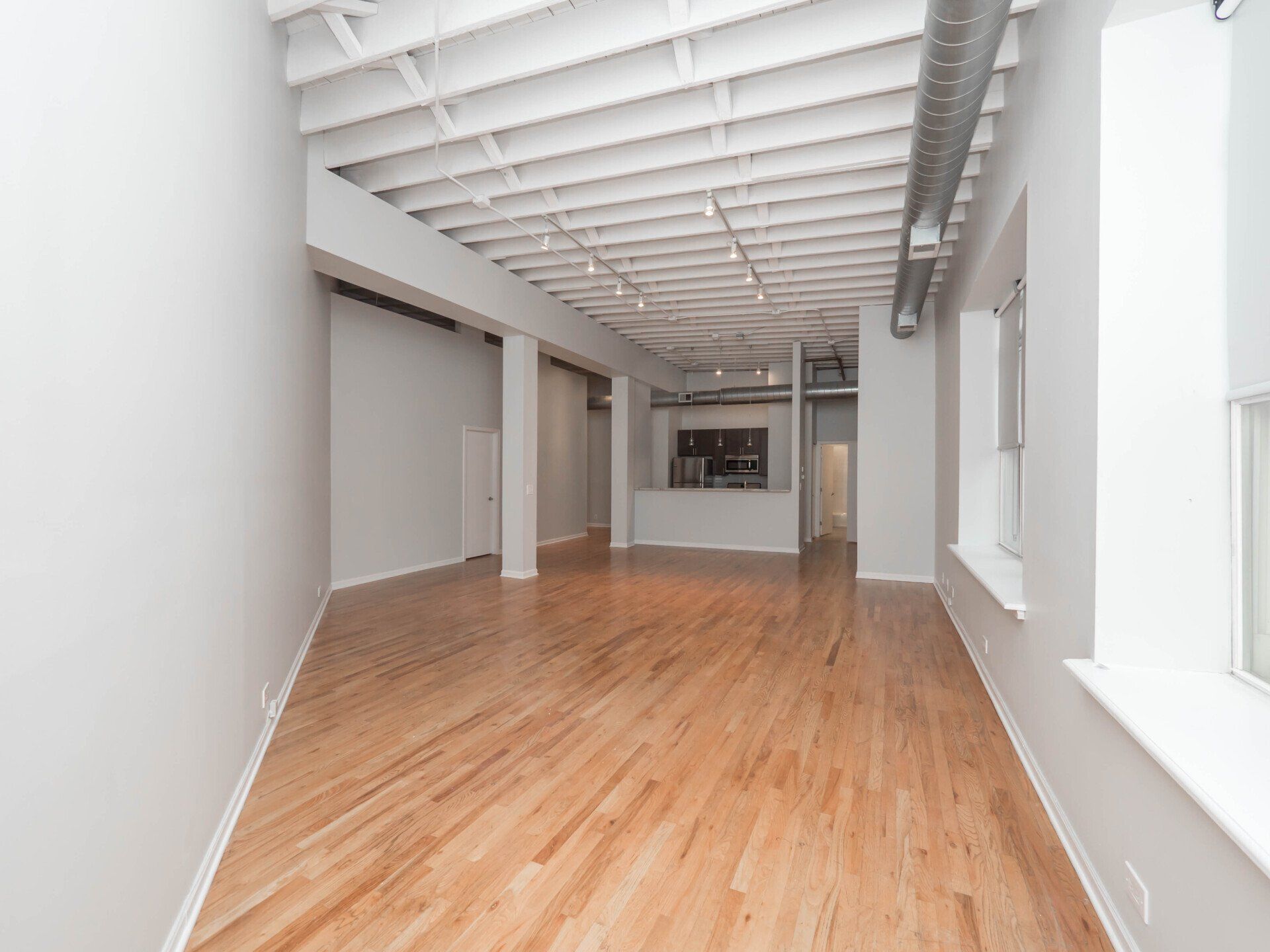 An empty room with hardwood floors and white walls at 1550 North Damen.