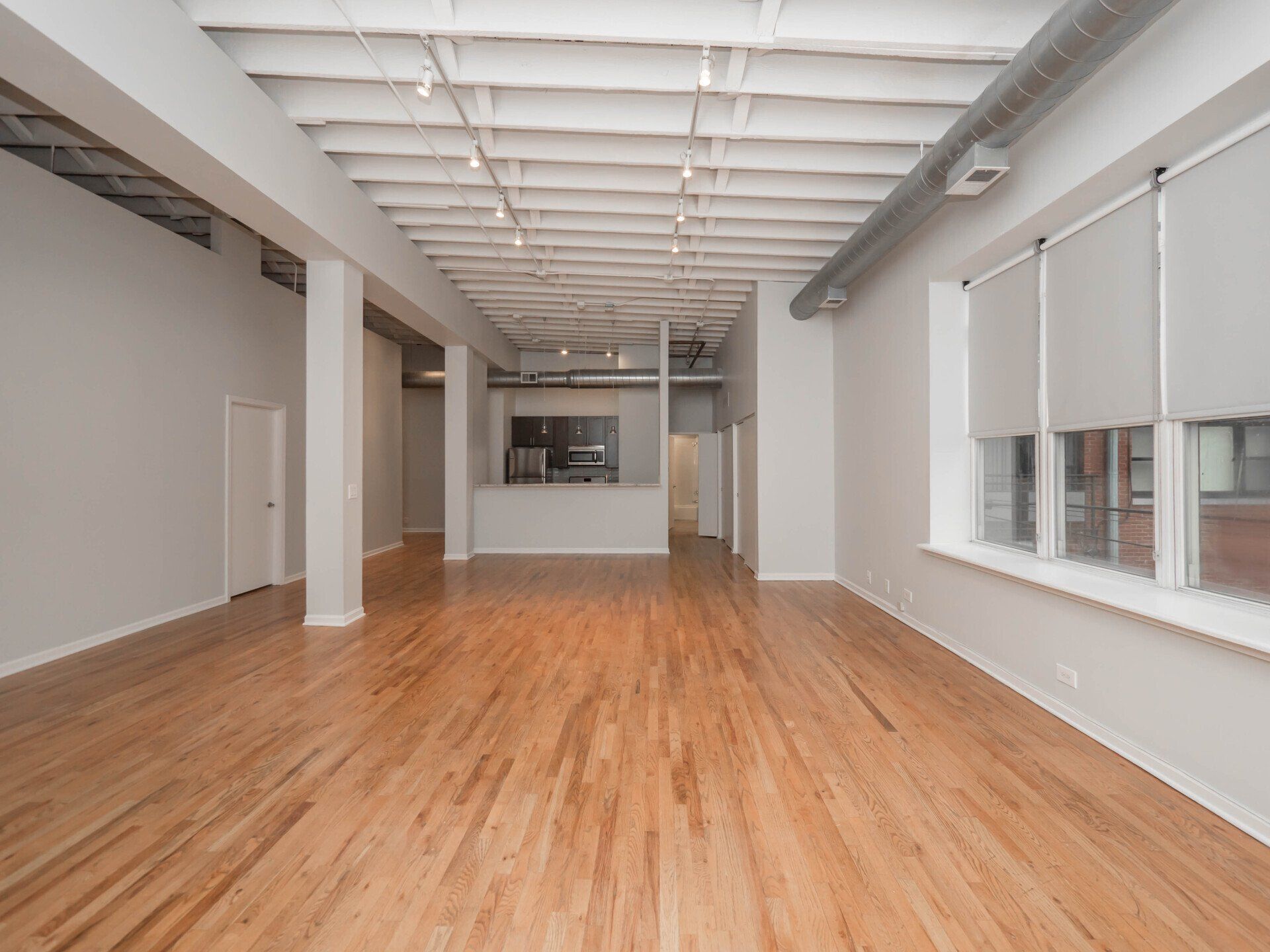 A large empty room with hardwood floors and white walls at 1550 North Damen.