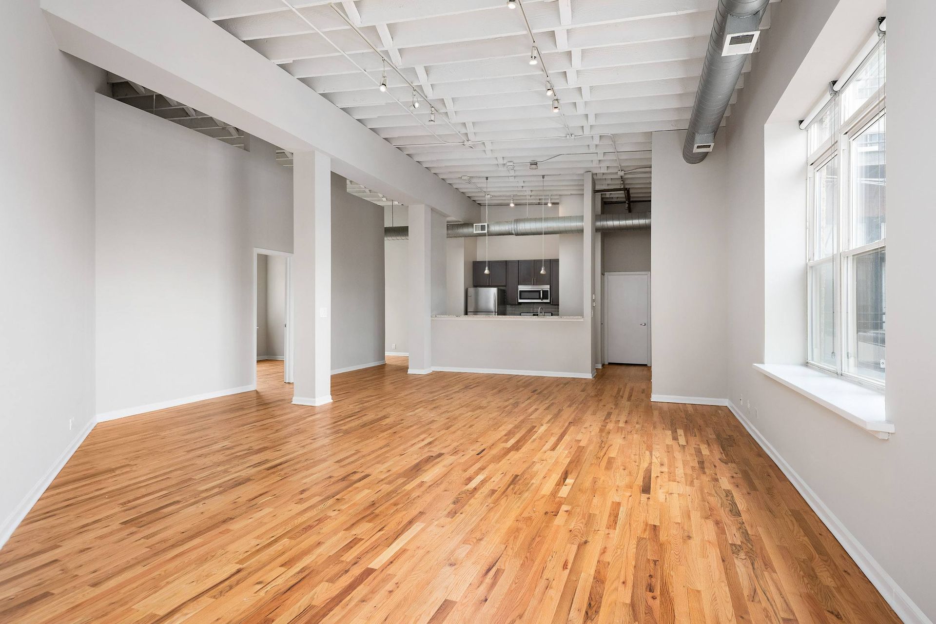 an empty room with wood floors and white walls