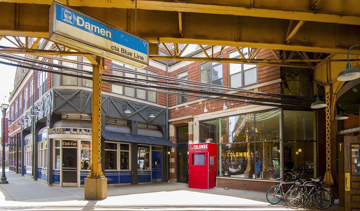 a street corner with a red phone booth and a building