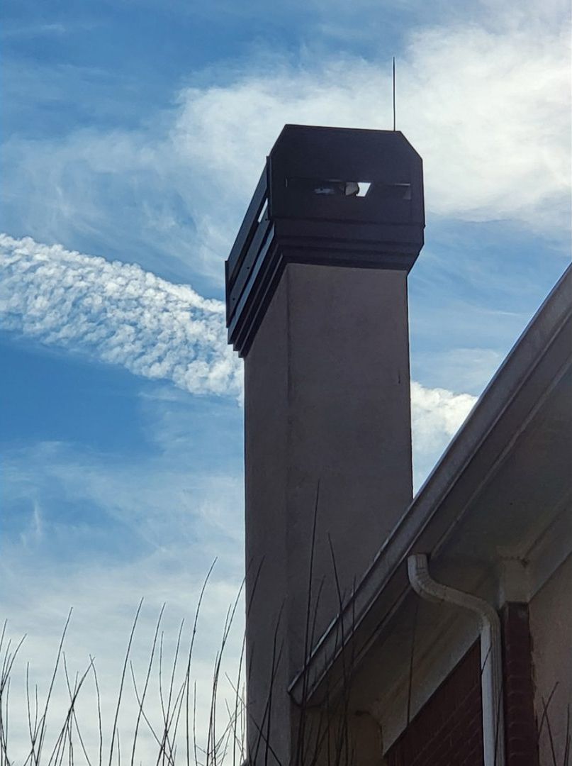 Open rectangular vent with metal mesh, set in brick.