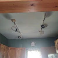 A kitchen with a ceiling light and a clock on the wall.