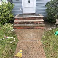 There is a broom on the sidewalk in front of the house.