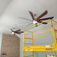 There are two ceiling fans hanging from the ceiling of a room.
