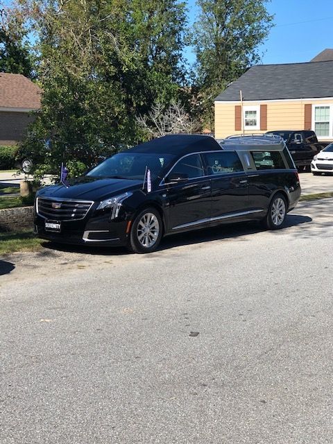 A black Cadillac hearse parked on a residential street.