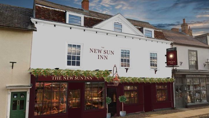 A white building with the words new sun inn on it