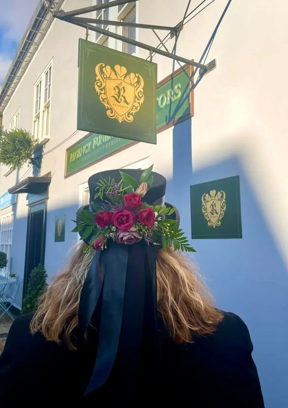 A woman wearing a top hat with flowers on it