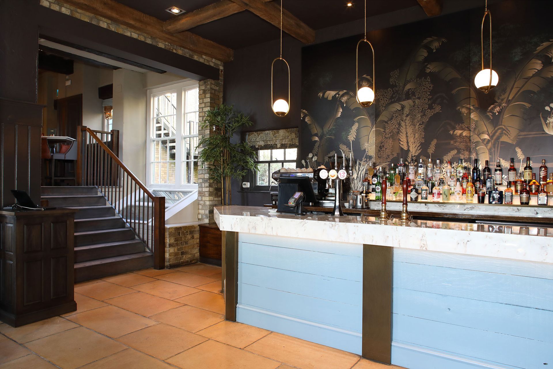 A restaurant with a bar and stairs leading up to it