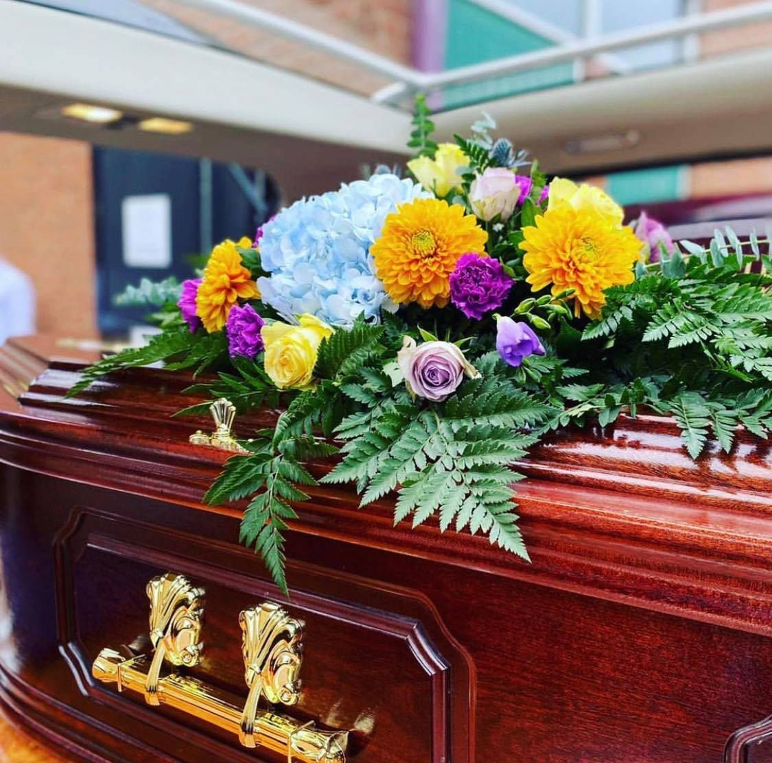 A wooden coffin with flowers on top of it