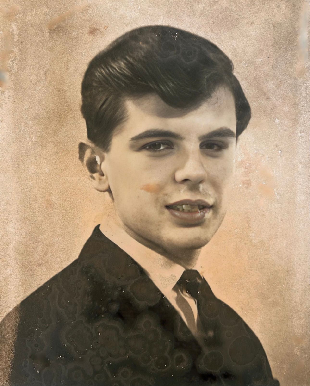 A black and white photo of a young man in a suit and tie