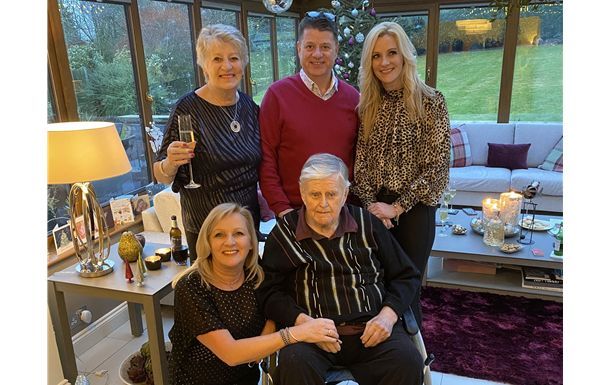 A group of people are posing for a picture in a living room.