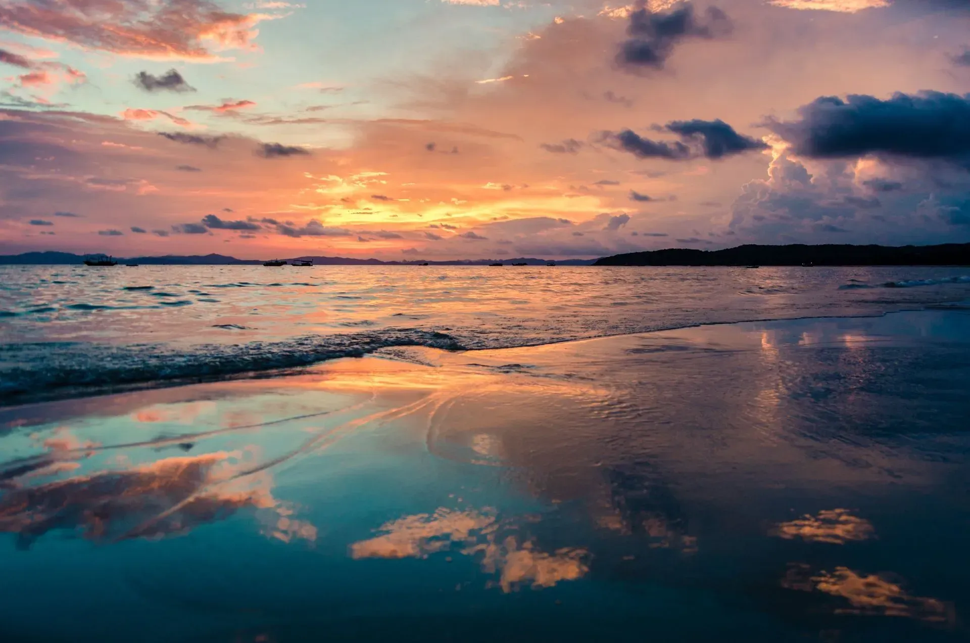 A sunset over a body of water with clouds reflected in the water