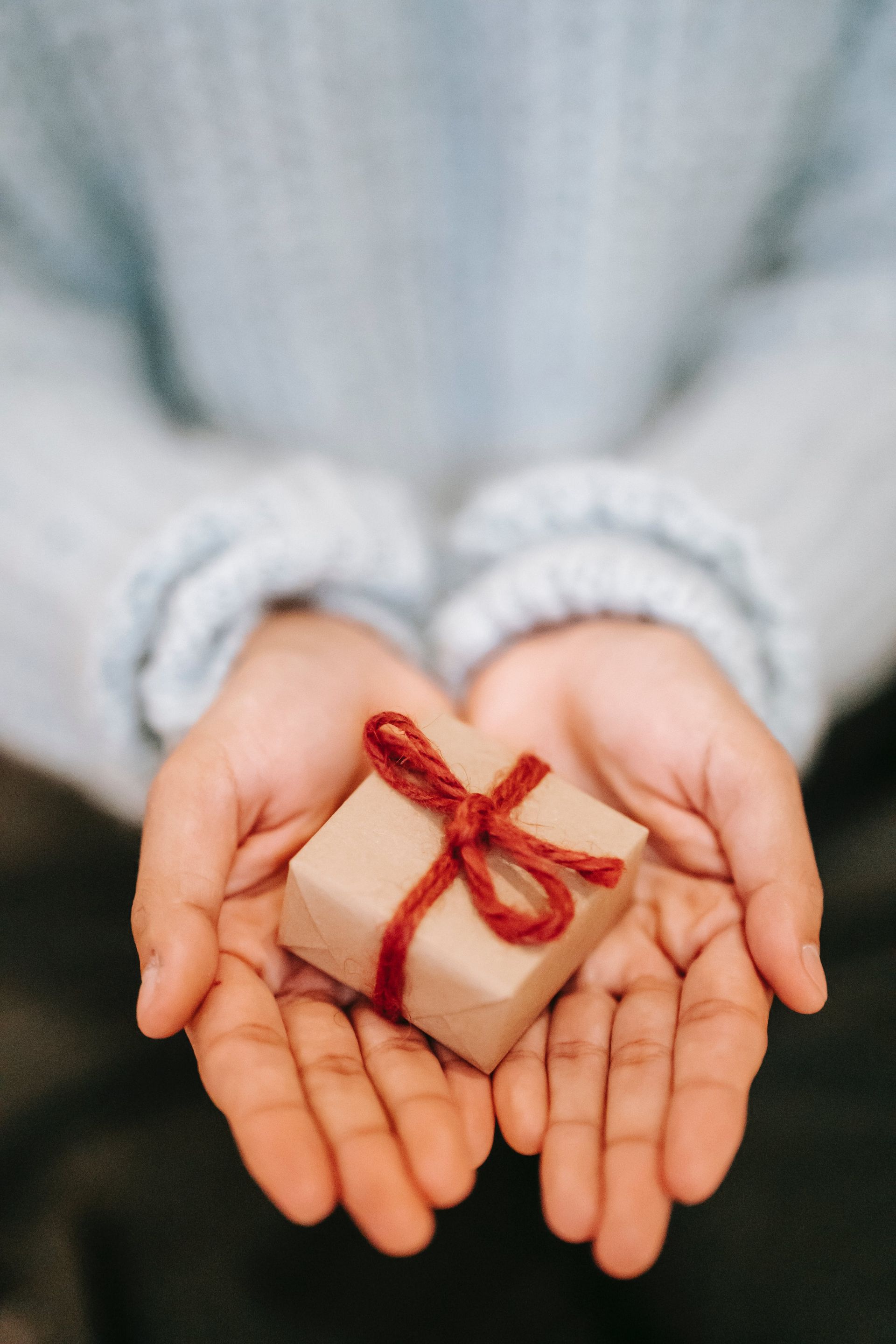 A person is holding a small gift in their hands