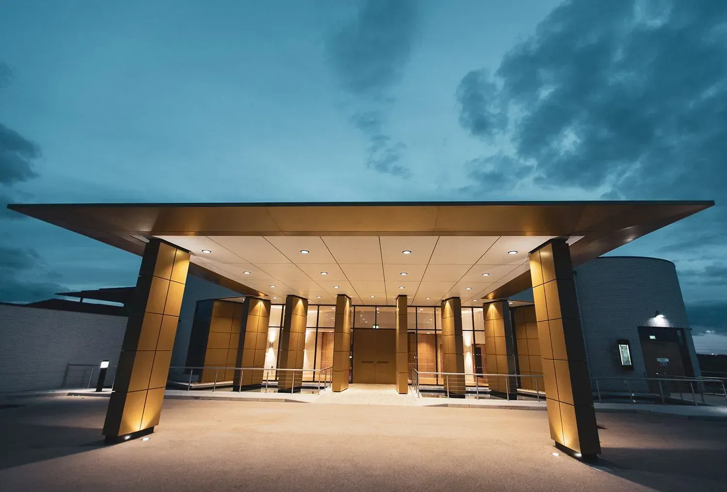 A large building with a covered entrance at night