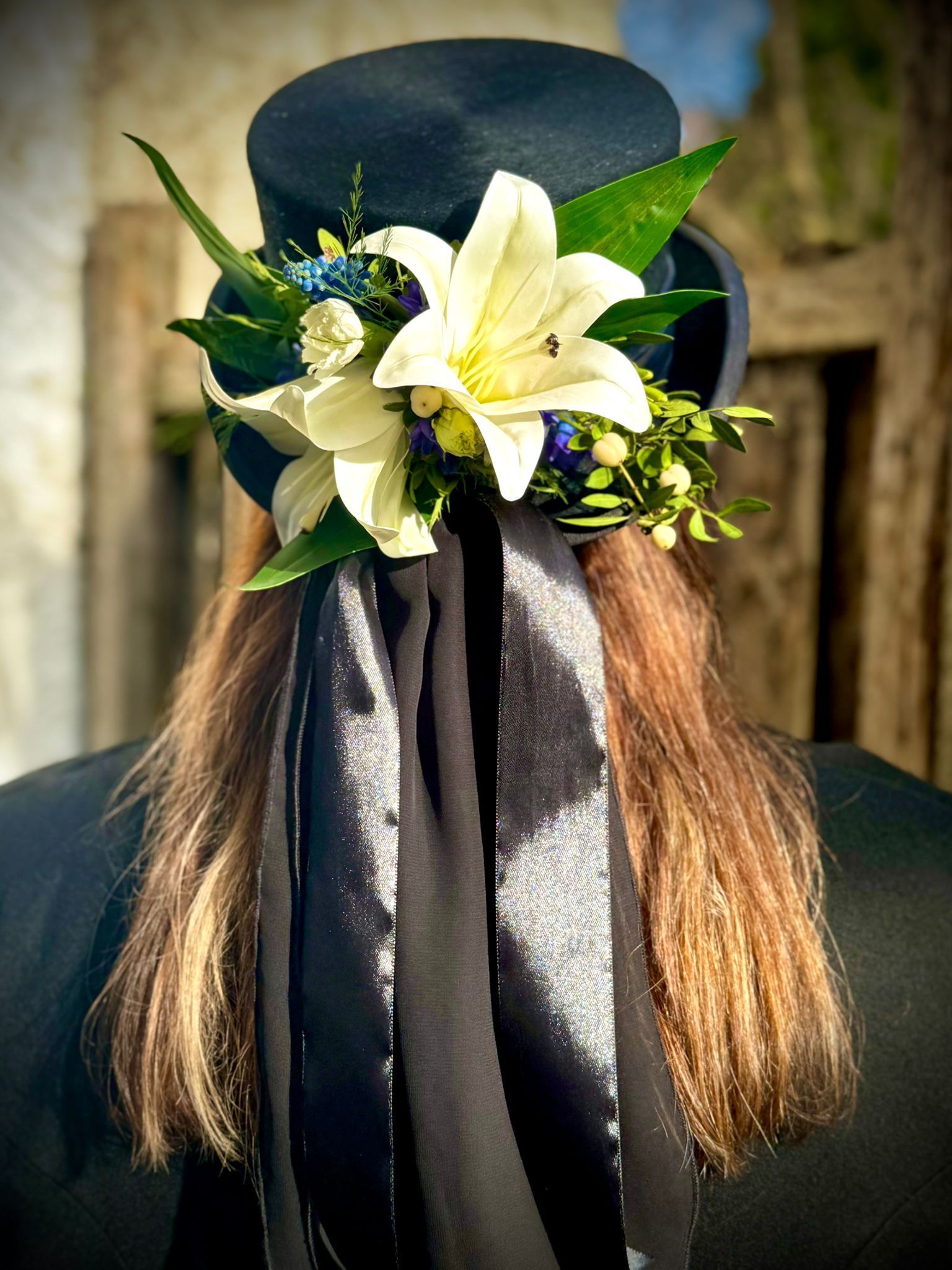 A woman wearing a top hat with flowers on it