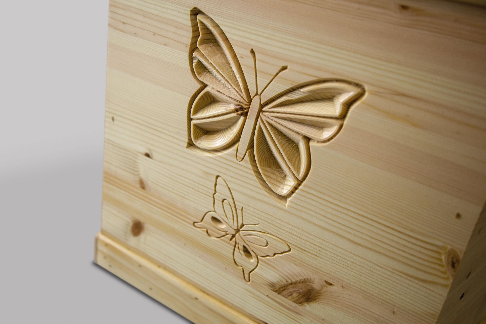 A wooden box with a butterfly carved into it